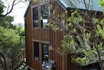 Image de Albie's cottage: Jolie maison en bois isolée sur un bloc de brousse au bord de la mer