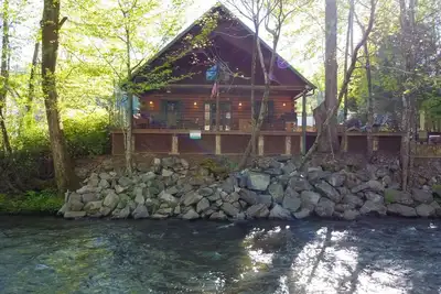 Image de Cette cabane en rondins se trouve littéralement sur les rives de la rivière Chattahoochee, dans le centre-ville de Helen. C'est un