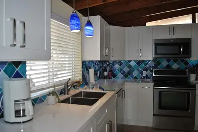 Image de Récemment rénové (complètement) devant la maison du canal avec une piscine et Tiki