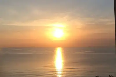 Image de Lever de soleil + coucher de soleil sur la plage de l'océan