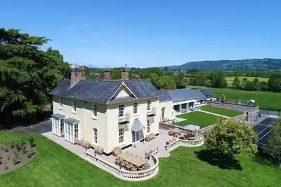 Image de Grande maison de vacances, 10 chambres avec salle de bains privative, piscine intérieure, court de tennis, bain à remous et salle de cinéma