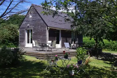 Image de La Mer à pied, maison en bois nichée dans la verdure.