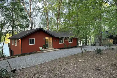 Image de Maison au bord du lac avec plage et accès en bateau.