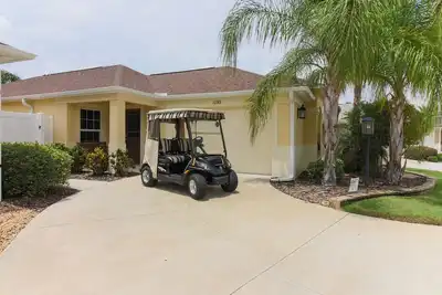 Image de Villa améliorée entourée de terrains de golf. Voiturette de golf à essence.