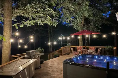 Image de Une belle maison récemment rénovée nichée sur un terrain riverain boisé avec un bain à remous.
