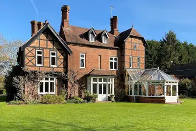 Image de Maison de campagne historique située dans de beaux jardins spacieux.