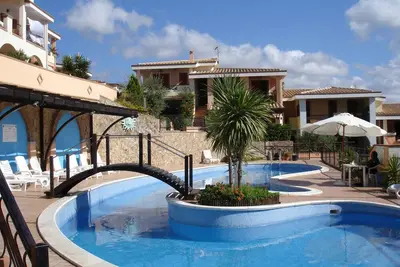 Image de Villasimius, appartement de deux pièces dans une résidence avec piscine.