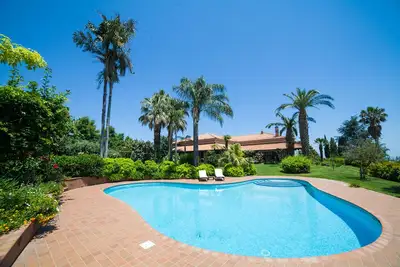 Image de Elégante villa dans jardin panoramique avec piscine privée.