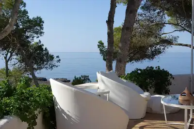 Grande villa au bord de l'eau avec jardin et terrasses.