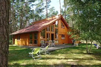 Image de Élégant, lumière maison en bois par les bois dans le voisinage immédiat du lac clair