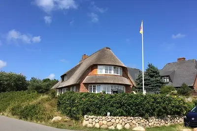 Image de Maison de vacances au toit de chaume, vue directe sur la mer des Wadden, avec un grand jardin