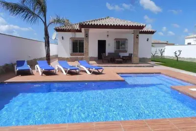 Image de belle maison avec grande piscine et terrasse de barbecue à Conil