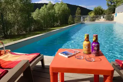 Image de Chalet typique en pierres doté d’une grande terrasse et d’une grande piscine