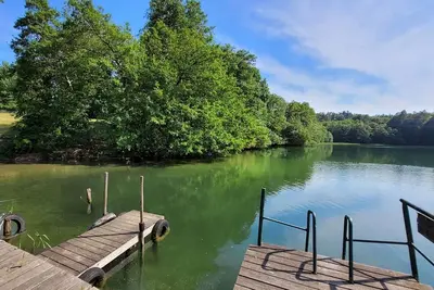 Image de Maison forestière idyllique sur le lac avec jetée, endroit isolé