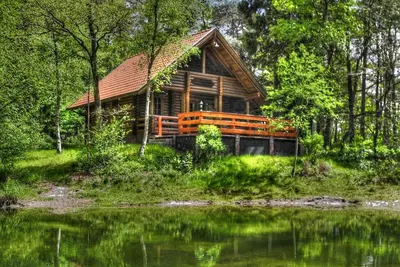 Image de Maison en rondins romantique sur un petit lac de forêt idyllique