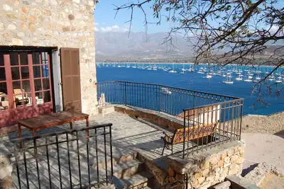 Image de maison citadelle sur les remparts, vue sur mer et montagne.