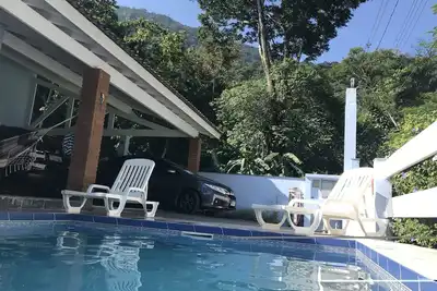 Image de Maison à Guaecá - sept suites, avec air conditionné dans les chambres et la piscine.