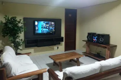 Image de Maison avec une grande salle pour le logement, aire de loisirs avec piscine et grilles de barbecue.