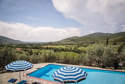 Image de Villa Angelisa D: Un appartement caractéristique et accueillant entouré de prairies et de collines verdoyantes.
