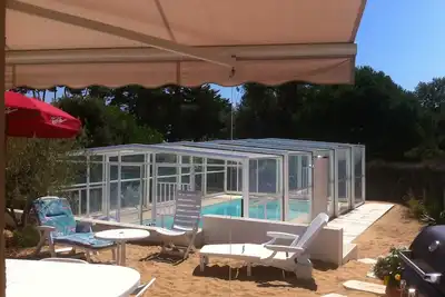 Image de Maison individuelle avec piscine privée et couverte, jardin de sable clos.