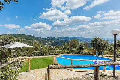 Image de Villa Alvise: Une charmante villa de deux étages située au sommet d'une petite colline.