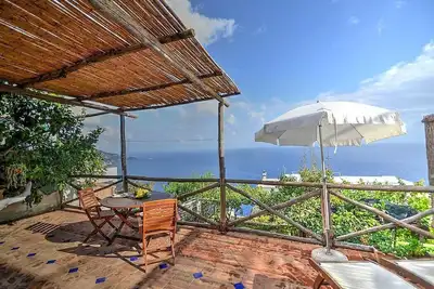 Image de Casa Chicca: Un chalet de charme construit sur le terrain en pente face à la mer.