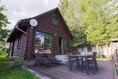 Image de Cabane en rondins sur le lac avec cheminée, jardin, terrasse, bateau, et beaucoup de nature