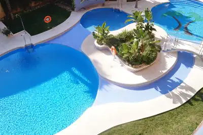 Image de L'un des meilleurs bâtiments, piscines et jardin en face de pistes de bowling de plage.