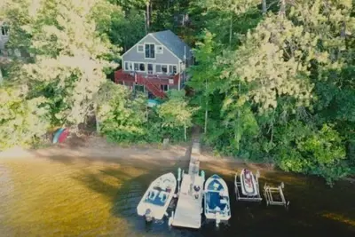 Image de Lakefront Cottage avec 100 'Sandy Beach, Dock, vues et salle de jeux.