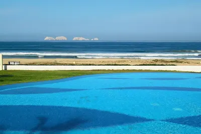 Image de Belle maison en bord de mer, piscine à débordement sur la baie océan Pacifique spectaculaire.