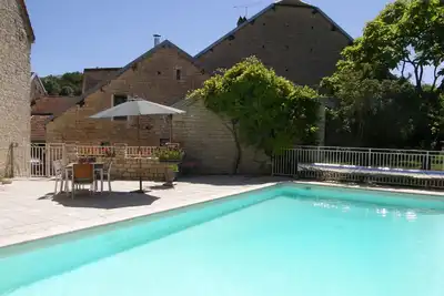Image de Conversion de grange conçue par un architecte avec piscine chauffée, bordures champagne \/ bourgogne