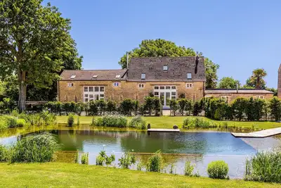 Image de Conversion de grange de luxe sur une ferme rurale des Cotswolds avec étang de baignade