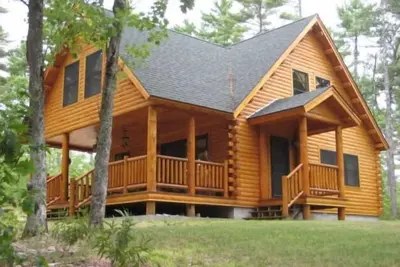 Image de Mousam Lake Lodge décoré de 3 chambres cabane en rondins avec plage de sable