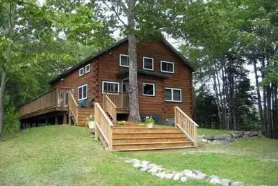 Image de Haut de gamme Log Cabin sur l'étang calme à proximité de l'Acadie et de Bar Harbor