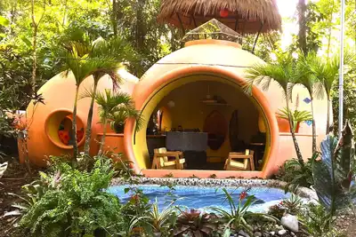 Image de Adobe style Dome Accueil dans un environnement verdoyant, Rainforest Réglage 3 minutes à pied de la plage