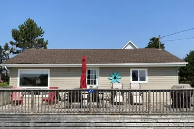 Chalet mignon avec vue sur l'eau. Étapes vers une plage de sable rouge sur la Rive-Sud.