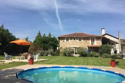 Image de Grande maison de campagne bien entretenue avec un grand jardin et une pataugeoire.
