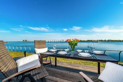Cet appartement de luxe est sur l'eau avec un sauna, une grande terrasse ensoleillée