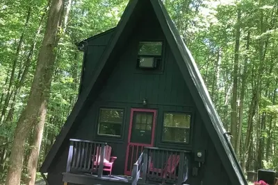Image de Cabine privée moderne et confortable avec bain à remous niché au bord de la montagne Coolfont