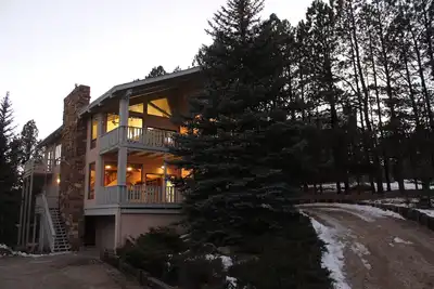 Image de Maison chevronnée pour enfants, adolescents et adultes, nichée dans les pins.