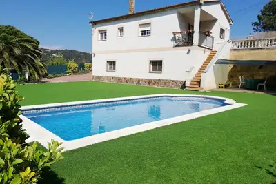 Image de Maison avec piscine privée, gazon artificiel, terrasses et jardins plats.