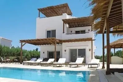 Image de grande villa avec piscine chauffée directement sur la plage du lagon avec ponton privé