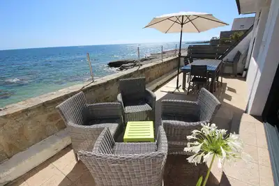 Image de Grande maison face Ă la mer, les pieds dans l'eau