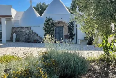 Beau trullo avec piscine d'eau salée niché dans sa propre oliveraie et ses jardins