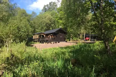 Image de Une charmante cabane avec poĂŞle Ă bois, bain Ă remous et vue imprenable sur le lac.