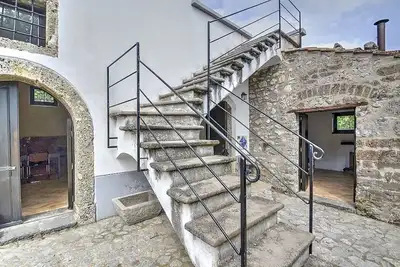 Image de Villa dei Faggi: Un appartement caractéristique et accueillant qui fait partie d'une ancienne ferme sur deux étages entourés de verdure.