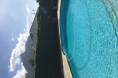 Image de maison familiale Perfec avec piscine et vue sur la montagne pour les vacances d'été.