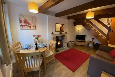 Image de Cottage romantique pour deux à Monyash. Poutres apparentes et poêle à bois.