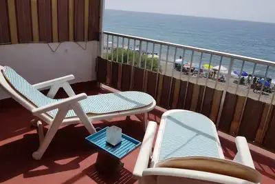 Image de Maison sur la plage avec grande terrasse et vue sur la mer.