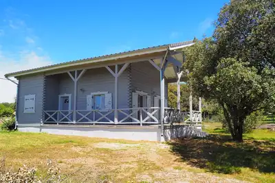 Image de Chalet du moulin : grand chalet en bois avec jardin arboré et terrasse couverte